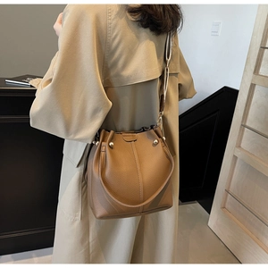 Brown litchi grain leather bucket bag with wide strap and gold rivet detailing