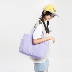 Detail view of light purple nylon tote bag with wide strap and side storage pocket