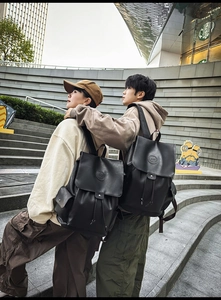 Detail of black leather backpacks with flap closure and side pockets for daily use