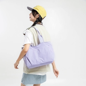 Detailed side view of a purple lightweight nylon tote bag showing the functional side pocket
