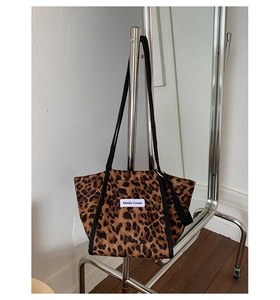 Détail du sac cabas léopard avec étiquette de marque et texture en toile résistante