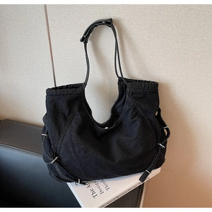 Dettaglio della borsa a nuvola in denim nero con fibbia in argento e coulisse laterale