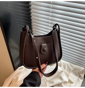 Detail of dark coffee litchi grain shoulder bag with front pocket and round buckle snap