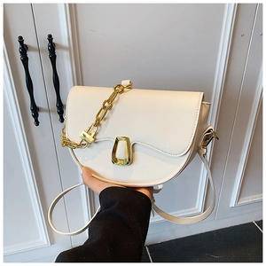 Detailed side view of beige crescent saddle bag with gold metal buckle and chain strap