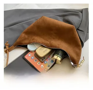 Detailansicht der großen Innenkapazität der braunen Wildledertasche mit Alltagsgegenständen