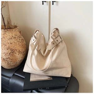 Detail of off-white leather hobo bag with silver buckle and natural soft folds