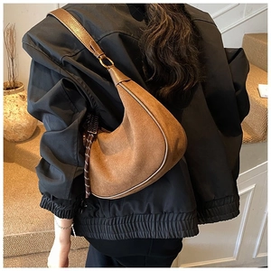 Détail du sac hobo en daim marron vintage avec texture mate et tirette de zip tressée