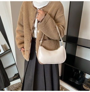 Detailed close-up of cream white half-moon underarm bag with smooth leather and gold zipper