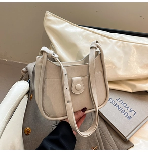 Detailed view of cream-white pebble leather bucket bag with unique U-shaped design