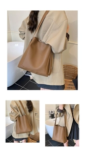 Detail of caramel brown litchi grain leather bucket bag showing texture and shoulder strap