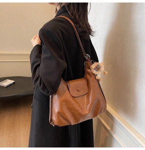 Brown faux leather tote bag with magnetic closure and cute lion plush charm detail