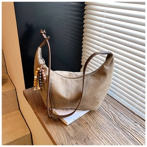 Detail der Hobo-Schultertasche aus khakifarbenem Wildleder mit braunem Lederriemen