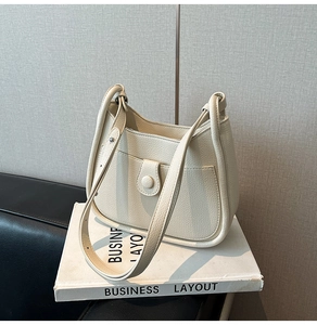 Detail of off-white lychee grain leather bucket bag with front pocket and double straps