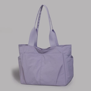 Detailed view of lavender nylon tote bag featuring wide straps and side pockets