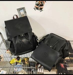 Detail of black pebbled leather backpacks with drawstring closure on industrial metal shelf