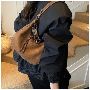Gros plan sur un sac hobo en daim marron mat avec détails de corde et bandoulière