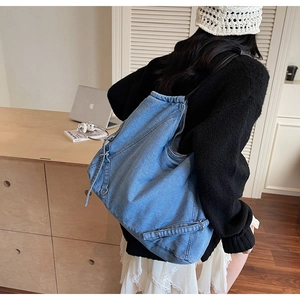 Dettaglio della borsa tote in denim lavato azzurro con coulisse e anelli in metallo
