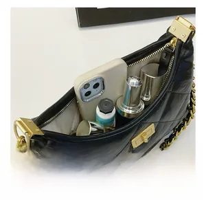 Detail view of black quilted chain bag interior showing space for phone and makeup