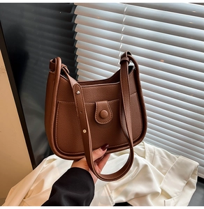 Close-up of caramel brown hobo bag with pebble leather texture and front pocket