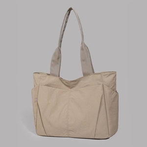 Detail of khaki water-resistant tote bag showing multi-pocket design and nylon texture