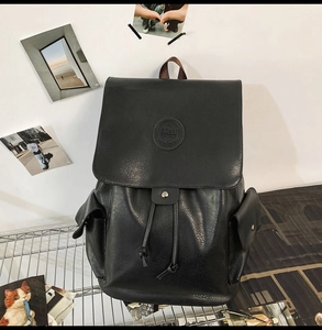 Detail of black vintage PU leather backpack with flap closure and magnetic snap pockets
