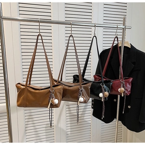 Detail view of colorful glossy patent leather shoulder bags with baseball charms