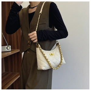 Close-up of pearl white quilted dumpling bag with gold chain strap and metal turn-lock