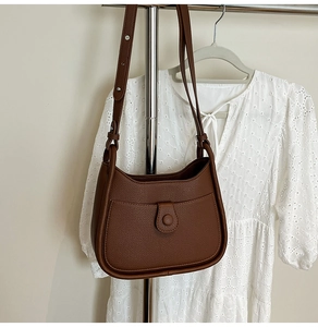 Detail of dark brown litchi pattern leather hobo bag with adjustable thin shoulder strap