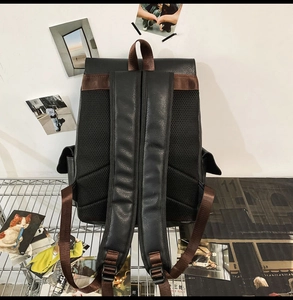 Detail view of vintage black leather backpack with breathable mesh back and brown straps