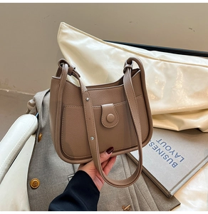 Detailed macro view of the brown litchi pattern leather texture and magnetic buckle flap