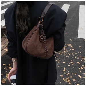 Sac hobo en daim marron mat avec bandoulière en cuir et pompon tissé en extérieur