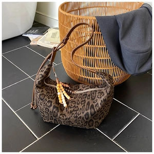 Nahaufnahme der Leopard-Schultertasche mit Holzperlen-Quaste und Lederriemen-Details