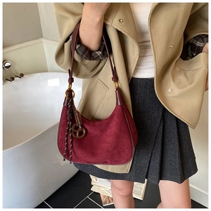 Sac hobo en daim bordeaux avec boucles vintage porté avec une tenue d'automne chic