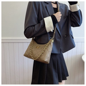 Detail of khaki quilted shoulder bag with gold chain strap and metallic turn-lock closure