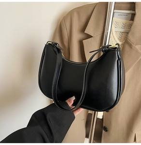 Detail of minimalist black matte leather hobo bag with gold zipper for women fashion