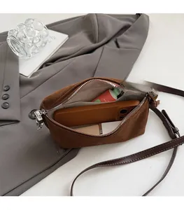 Detail view of suede square bag interior with herringbone lining and mobile phone storage