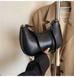 Detail view of black hobo shoulder bag with smooth leather finish and gold metal hardware