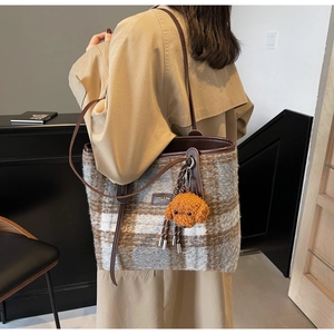 Détail du sac cabas à carreaux en laine avec finitions cuir et breloque peluche