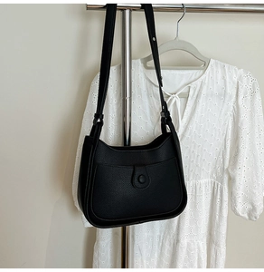 Detail of black lychee texture bucket bag on display with adjustable shoulder strap