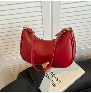 Detail showing red matte leather hobo bag with golden zipper and metal buckle