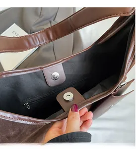 Detail of deep brown tote bag interior featuring magnetic closure and zip pocket