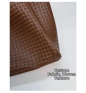 Vue détaillée de la texture en cuir tressé marron foncé de ce sac cabas de qualité