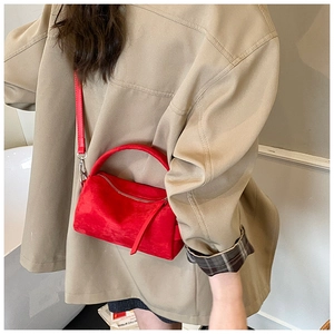 Vista dettagliata di una borsa vintage in pelle scamosciata rossa con manico e tracolla