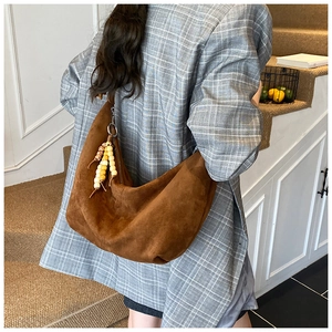 Detail einer großen braunen Wildleder-Hobo-Tasche mit Perlenfransen und Reißverschluss