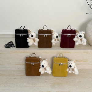 Detail von fünf matten Wildleder-Eimertaschen mit Teddybär-Anhängern auf Steinstufen