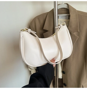 Close-up of cream PU leather hobo bag with gold-tone hardware and smooth texture