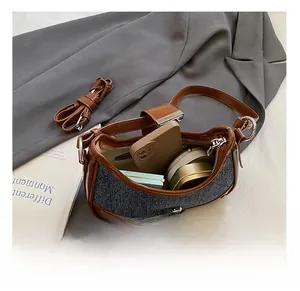 Top view of the interior capacity of a grey denim and brown faux leather bag