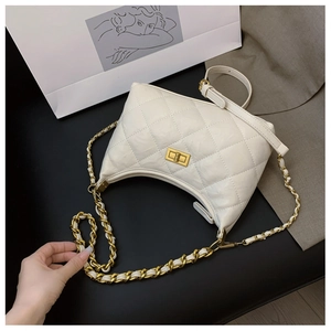 Detailed close-up of white quilted leather dumpling bag with gold chain strap and square lock