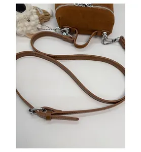 Detailansicht der braunen Wildleder-Mini-Beuteltasche mit silbernem Reißverschluss