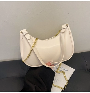 Detailed close-up of cream leather hobo bag with a gold chain strap and metal zipper